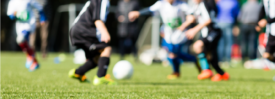 Kids on a soccer field playing soccer.